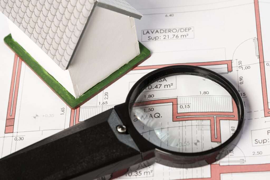 high-view-real-estate-plans-with-magnifying-glass-min